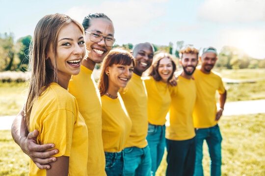 Community of multiracial young people smiling at camera outside - Cheerful group of university students standing in college campus - Team building concept with guys and girls hugging together