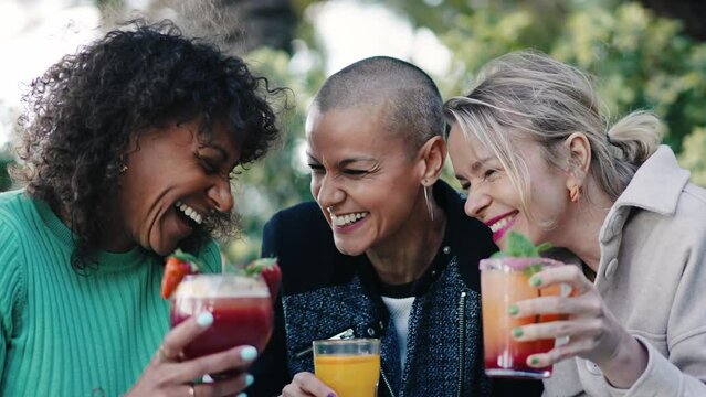 Women friends hanging out enjoying summer drinks together at restaurant