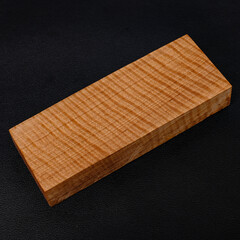 Sawn timber of rare maple wood with a beautiful pattern for crafts on black background