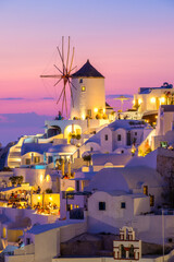 Oia village, Santorini, Greece. Vacation. View of traditional houses in Santorini. Small narrow streets and rooftops of houses, churches and hotels. Landscape during sunset.