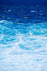 The sea as a background. Waves and sea foam. Water color gradient. Nature photo for design and background.