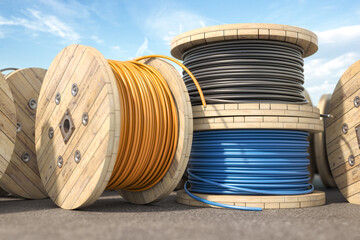 Wire electric cable of different colors on wooden coil or spool in warehouse. - 604618944