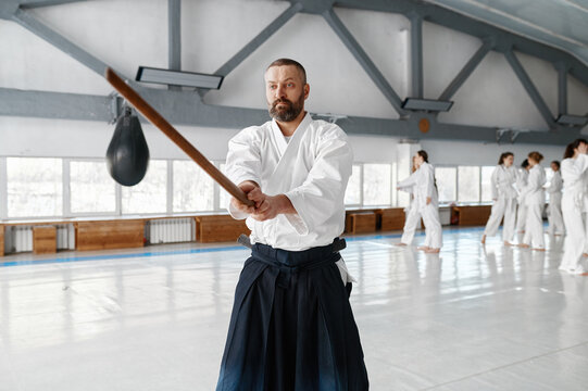 Portrait of aikido sensei master with wooden sword at group training