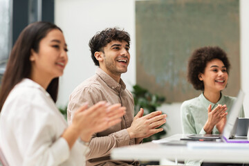 Fototapeta premium Group Of Joyful Business People Clapping Hands Sitting In Office