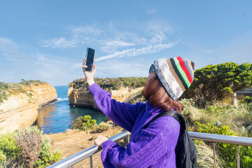 Middle-aged Asian woman backpacking backpacker excitedly arrives at her destination holding...