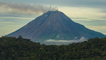 Mount Sinabung active stratovolcano covered with clouds. Sumatra, Indonesia.