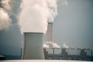 Twin nuclear power stacks rise above. A power plant in Europe.