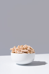 Espirales de pasta integral. Macarrones de trigo orgánico sobre fondo gris