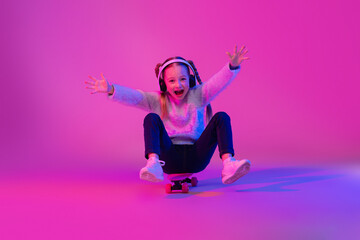 Emotional cute school aged girl having fun with skateboard