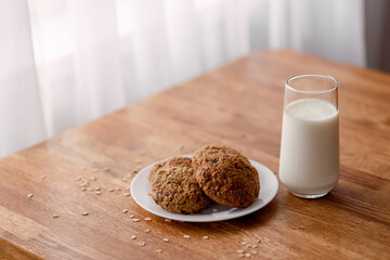 Homemade oatmeal cookies with oats, eggs and flour free on brown dark wooden table, side view.