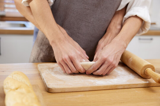 close up gay couple hands making a bread together in the kitchen