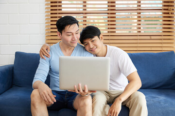 Fototapeta premium LGBT gay couple using laptop computer on sofa