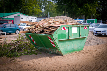 wood waste is collected on a construction site in a green waste container