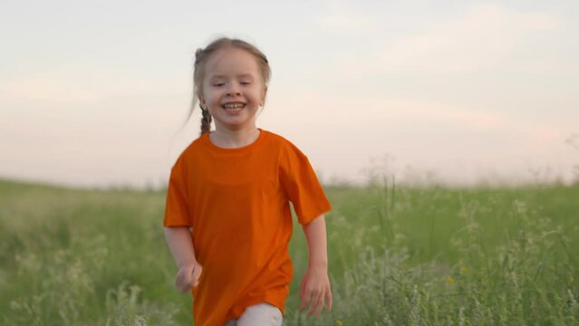 Happy little girl dreams, run in nature. Child running through field of flowers. Happy child, girl runs in green grass, raising her hands, joy, smiles laughter. Childrens fantasies. Happy family