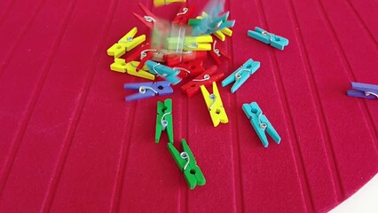 colorful pegs falling on red ground
