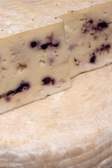 Cheese with berries. Tasting semi-hard cheese.