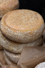 Aged cheese. Round pieces of cheese at the market.