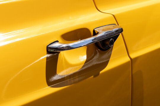 Door handle of a yellow vintage car. © Serhii