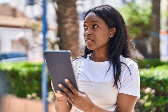 Young african american woman smiling confident using touchpad at park