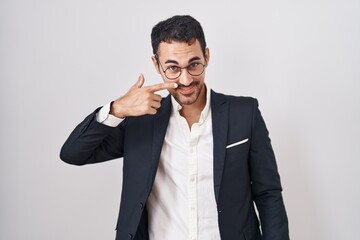 Handsome business hispanic man standing over white background pointing with hand finger to face and...