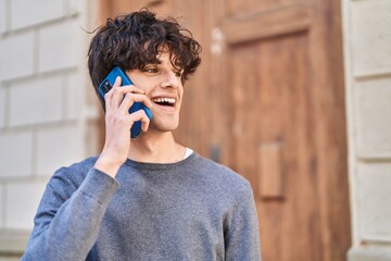 Young hispanic man smiling confident talking on the smartphone at street