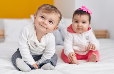 Adorable boy and girl smiling confident sitting on bed at bedroom