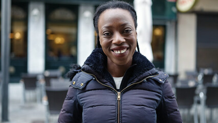 African american woman smiling confident standing at coffee shop terrace
