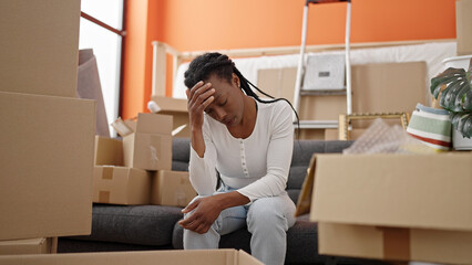 African american woman sitting on sofa with stressed expression at new home