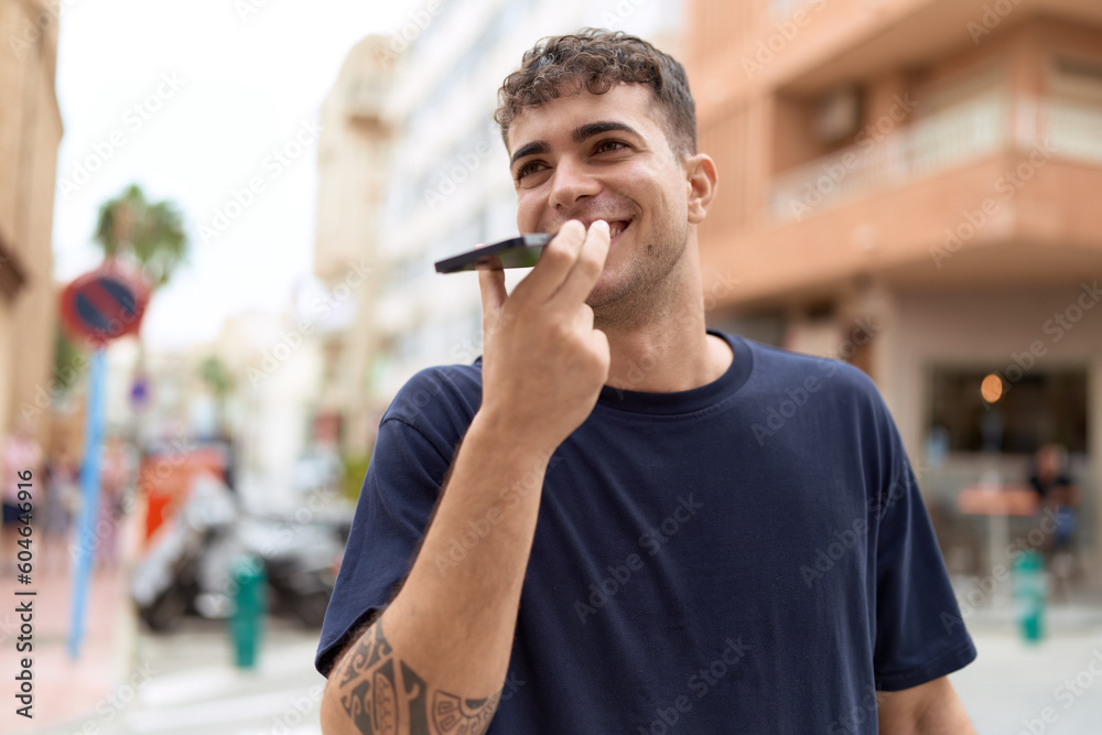 Canvas Prints Young hispanic man smiling confident talking on the smartphone at street