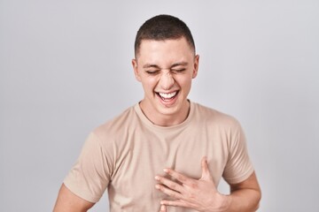 Young man standing over isolated background smiling and laughing hard out loud because funny crazy...
