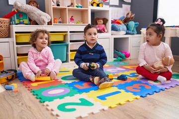 Group of kids sitting on floor playing with toys at kindergarten