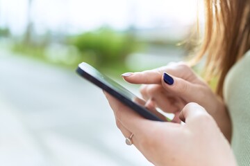 Young beautiful woman using smartphone at street