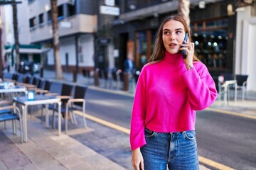 Young woman talking on the smartphone at street