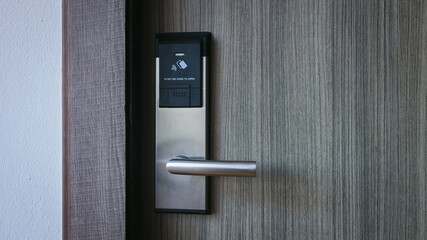 Smart card door key lock system in hotel. Hotel electronic lock on wooden door. Entrance door with...