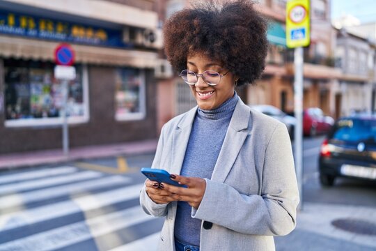 African american woman executive smiling confident using smartphone at street