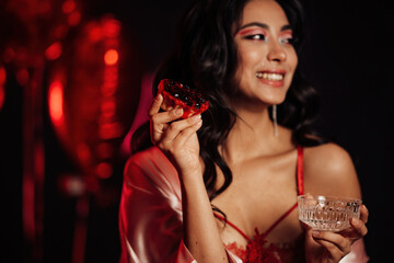 Portrait of smile sexy asian girl glam makeup in red lingerie with cupcake and glass of champagne