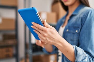 Young beautiful hispanic woman ecommerce business worker using touchpad at office