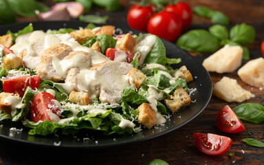 A delicious chicken caesar salad with parmesan cheese, tomatoes, croutons and dressing