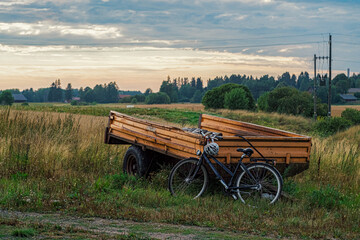 Bicycle leaning against a trailer in the countryside