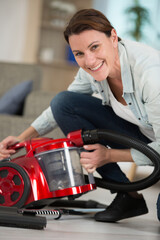 happy woman using a vacuum cleaner