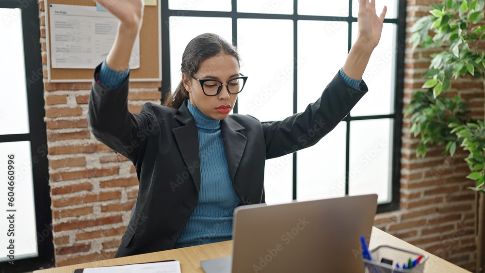 Wall mural young beautiful hispanic woman business worker stressed using laptop at office