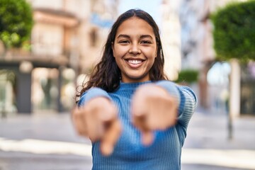 Fototapeta na wymiar Young african american woman smiling confident pointing with fingers at street