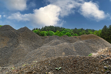 Small gravel from granite. A large pile of building basalt in a quarry.