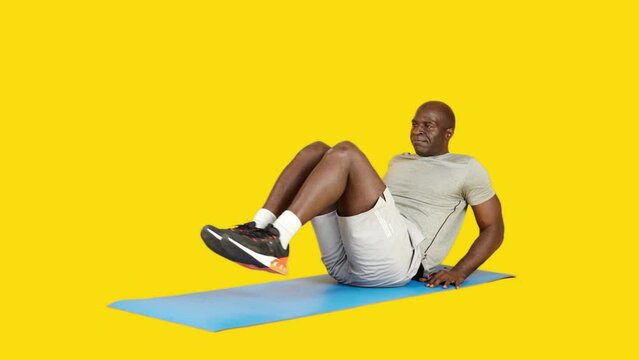 African strong man doing leg raise crunch on a mat