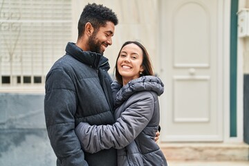 Man and woman couple smiling confident hugging each other at street