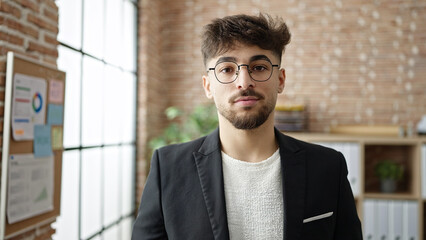 Young arab man business worker standing with relaxed expression at office