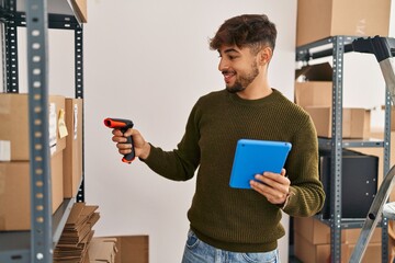 Young arab man ecommerce business worker scanning package at office