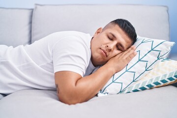 Young latin man lying on sofa sleeping at home