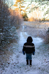 Child walking on snow covered trail