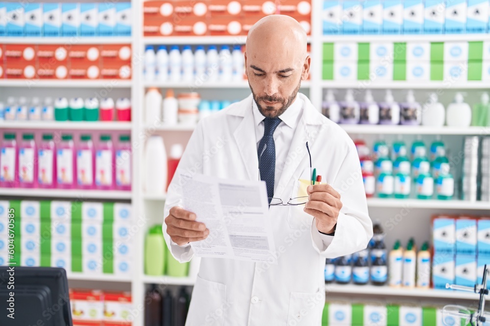 Sticker Young bald man pharmacist reading prescription at pharmacy